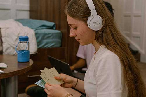 A student studying in their room with headphones on