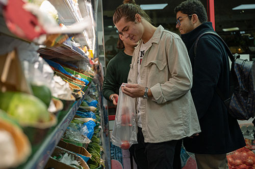 A student grocery shopping in a supermarket