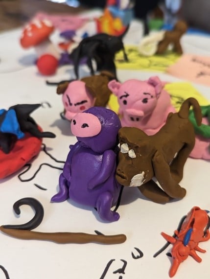 Clay versions of an Anopheles mosquito, two macaques, and pigs.