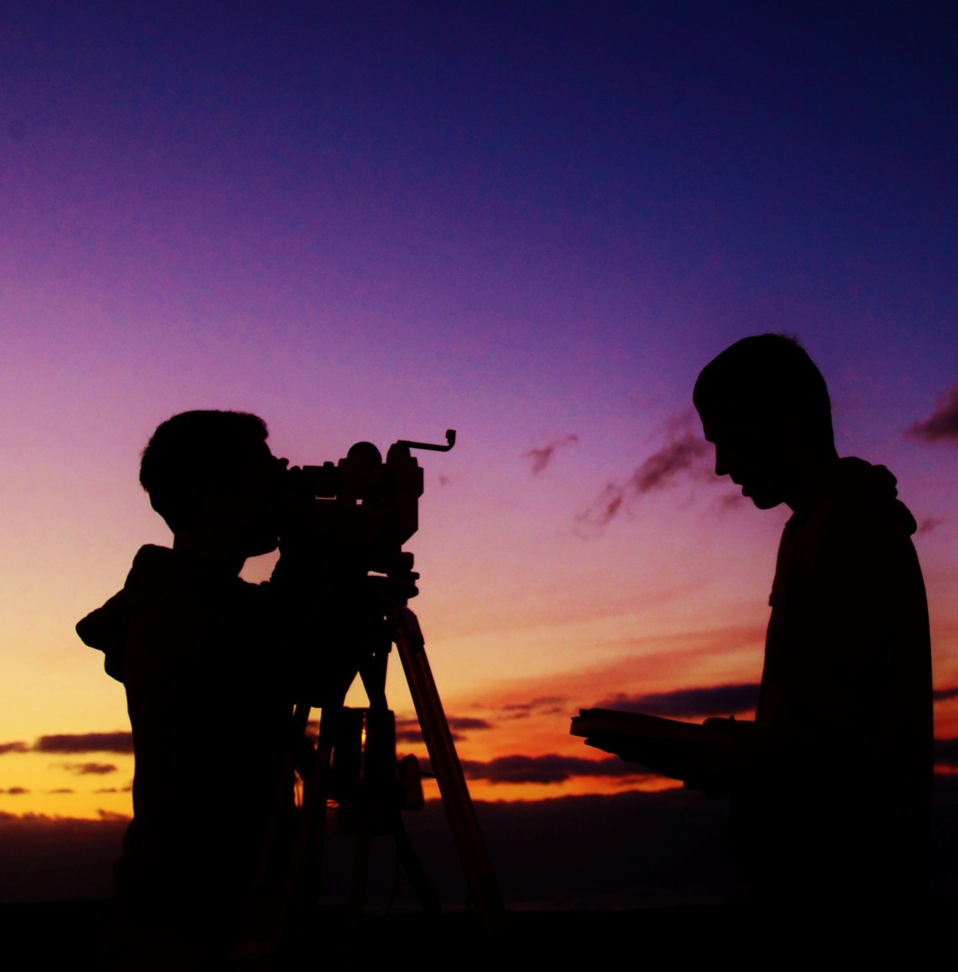 Silhouettes of two students looking at a sunset