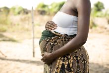 A pregnant African woman holding her stomach. Credit: himarkley, Getty Images