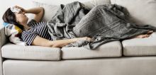Woman laying on the couch sick with flu
