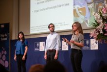 Three students speaking at the Map the System competition