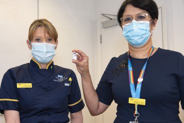 Photo | Nurses Sam Foster and Meghana Pandit display a vial of the Oxford coronavirus vaccine