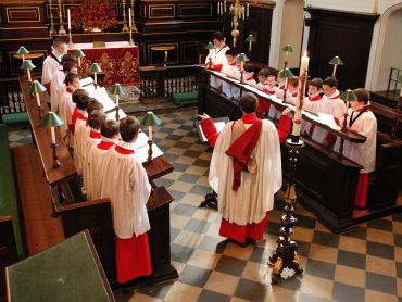 boys in robes singing in a church