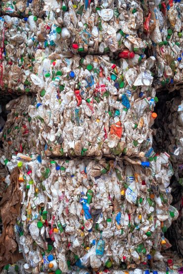 Bundles of pressed plastic bottles at a waste recycling plant. 
