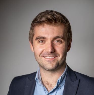 Portrait photo of Professor Robert House, a white man with short brown hair wearing a dark blue suit jacket and light blue shirt.