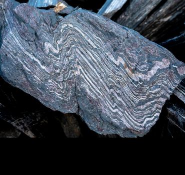 A rock with a distinct pattern of alternating light and dark bands. 