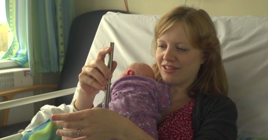 Rachel Edwards, aged 33 and from Oxford, who gave permission for her son Alex to take part in the study demonstrates how the retracting rod works on herself.