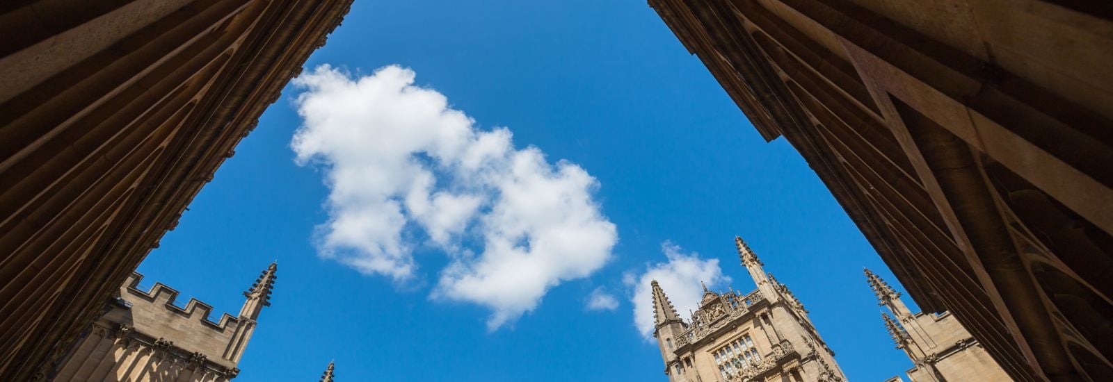 Looking up at blue sky from the exterior of the old library, Bodleian Library