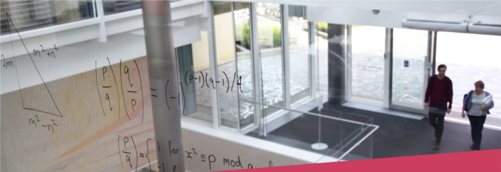 Equations written on glass looking over the entrance to the Mathematical Institute.