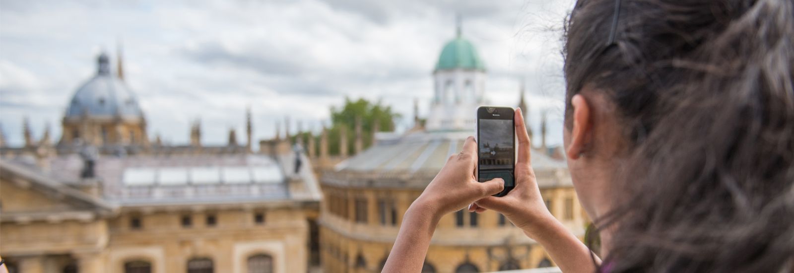 Visitor taking a photo of Oxford skyline on phone