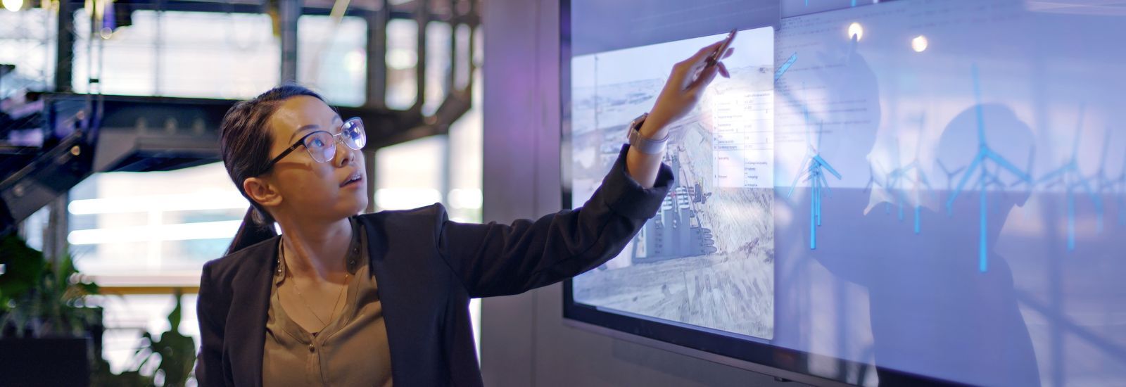 Woman pointing to data on a large screen