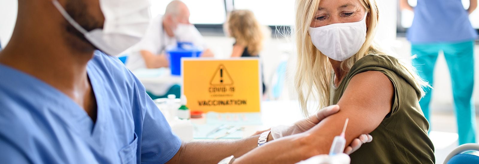 Woman with face mask getting vaccinated