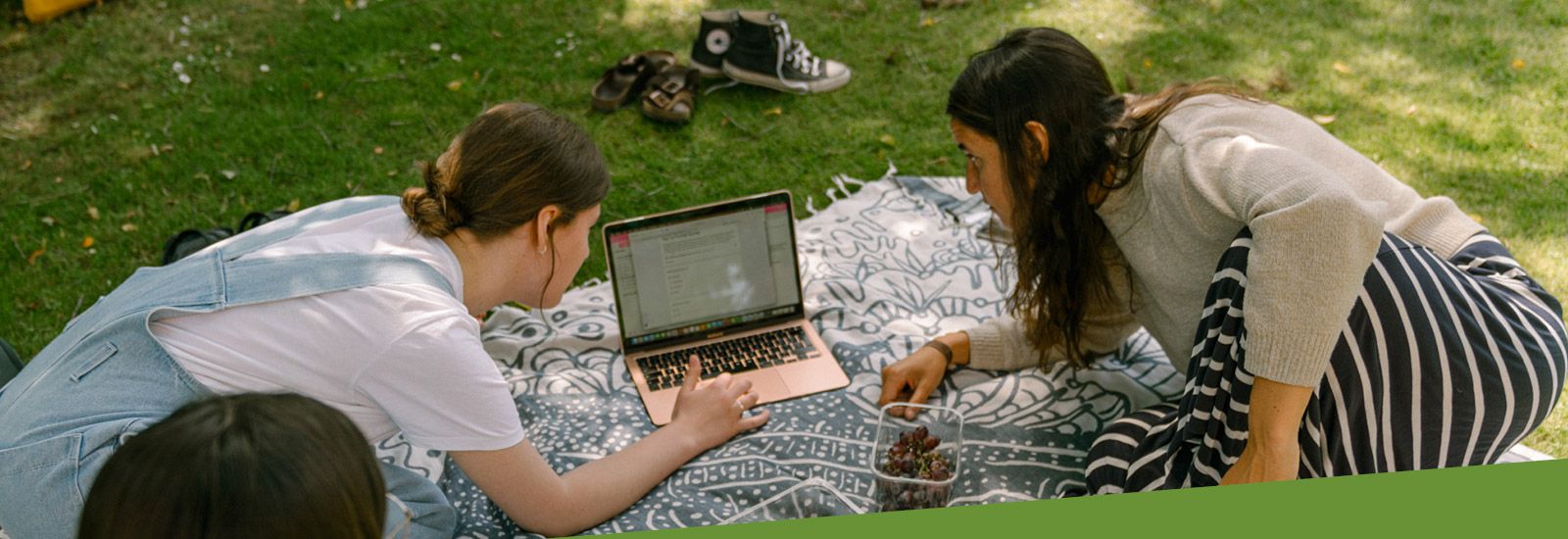 Two students with a laptop outside
