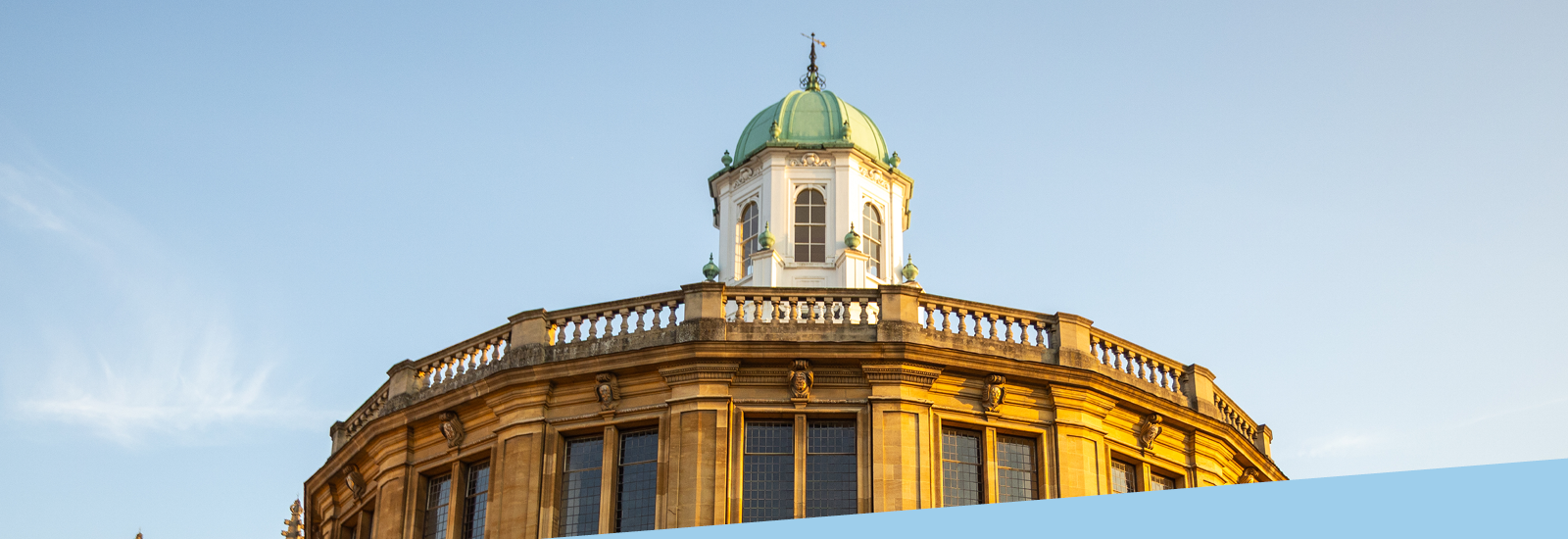 Sheldonian Theatre in sunlight against a blue sky background
