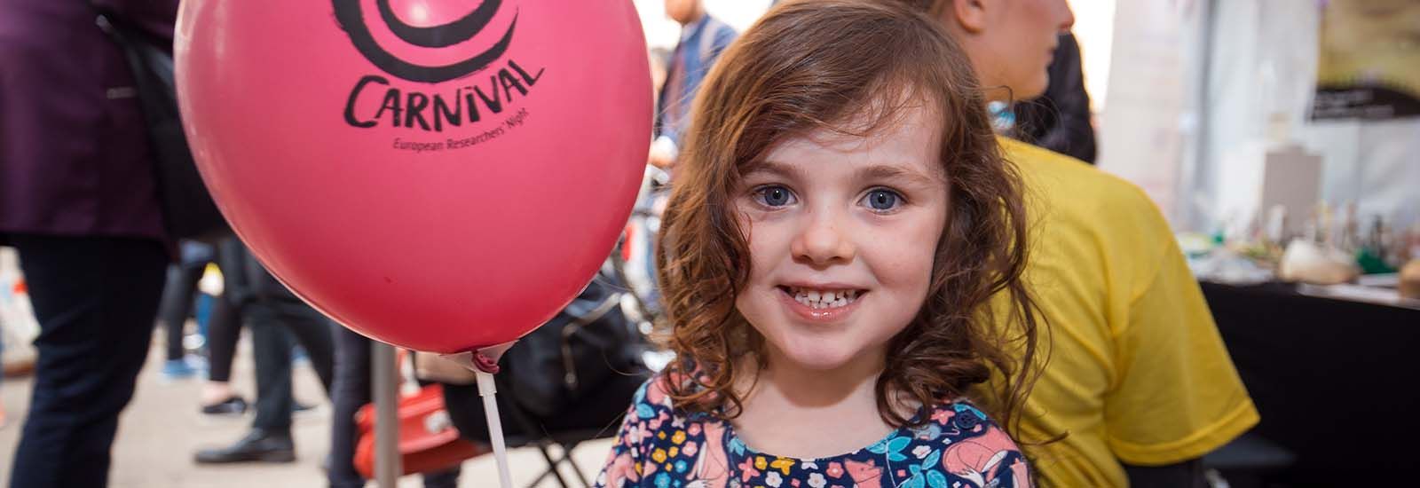 Photograph of a child with a balloon at the Curiosity Carnival