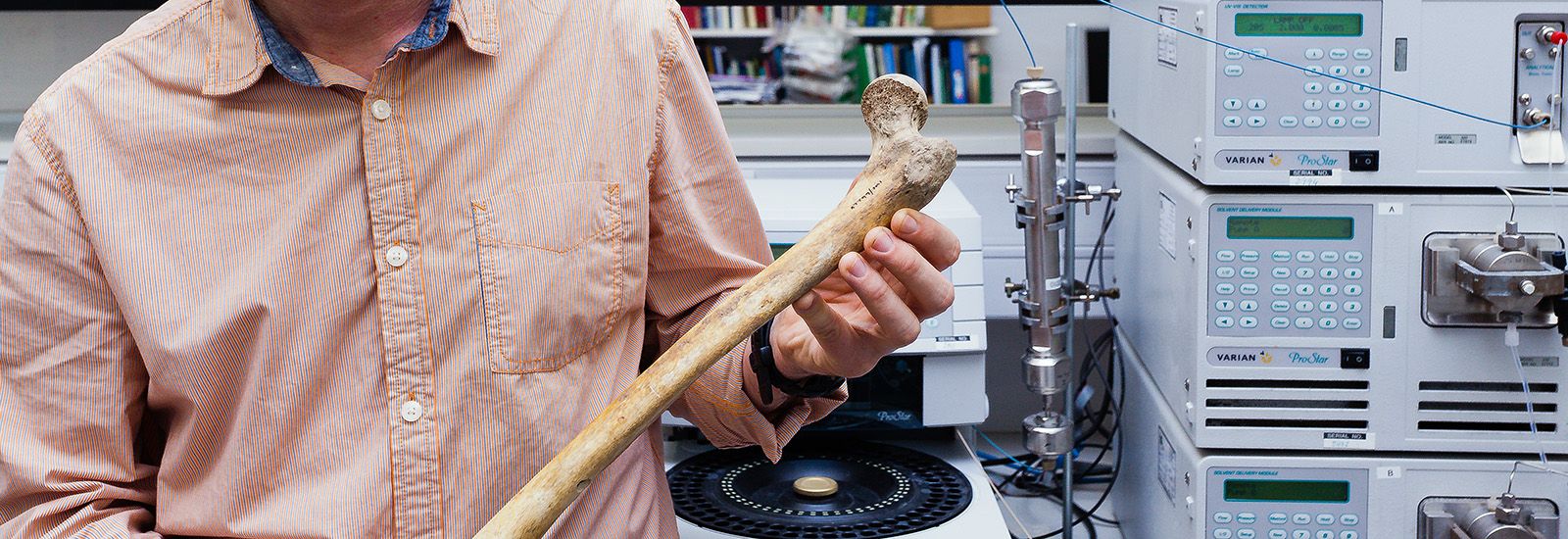 A person holding a human femur in a lab