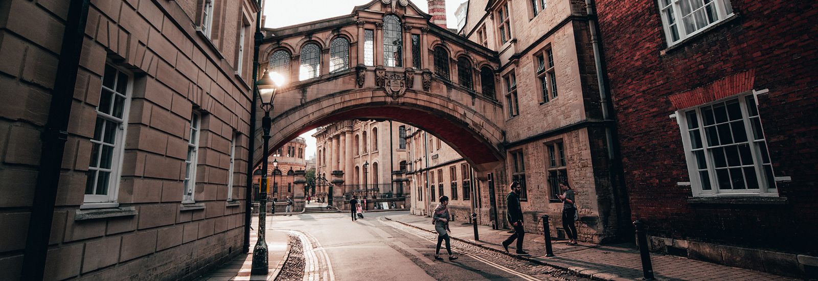 People walking under the Bridge of Sighs at sunset