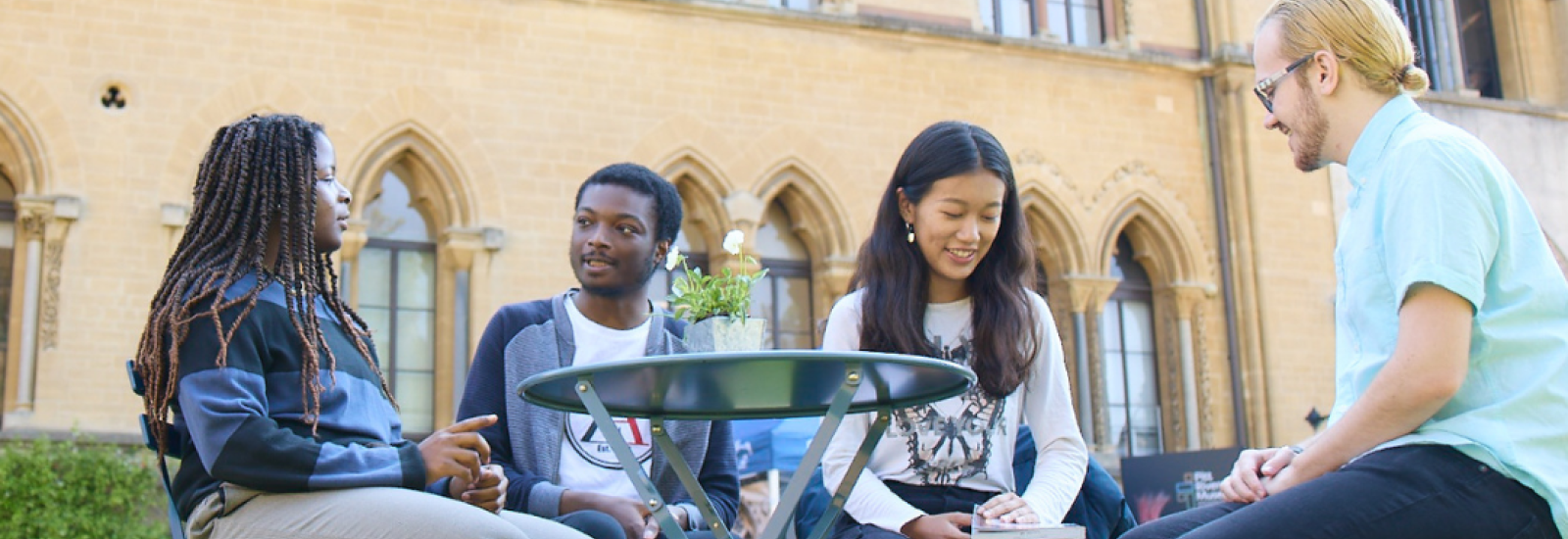 Four students sitting outside the Natural History Museum 