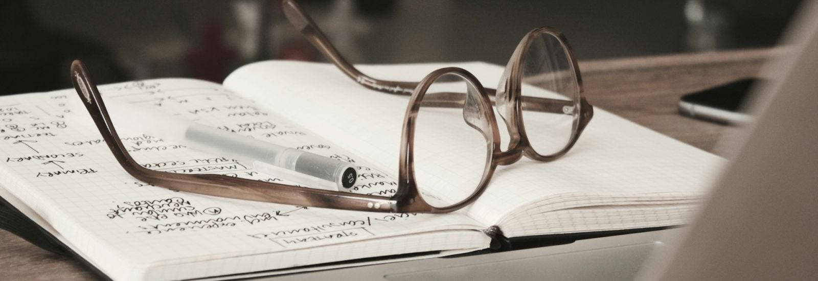 A pair of glasses resting on a notebook.