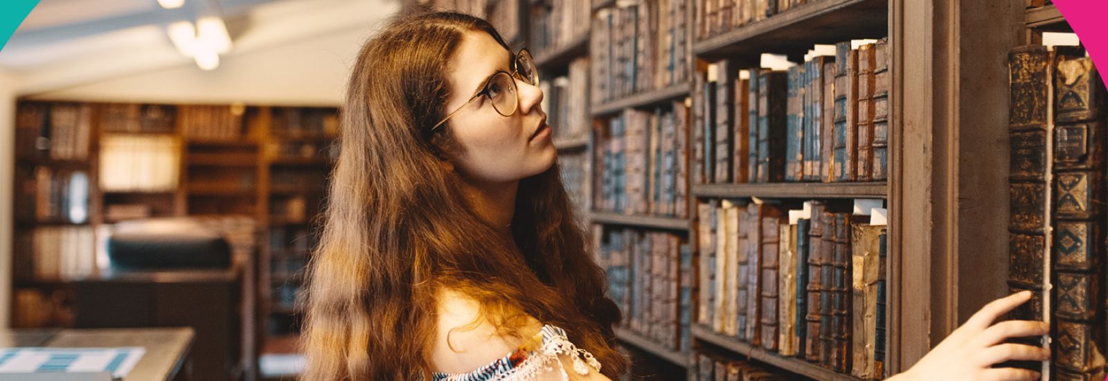 An intern looking at books on a shelf