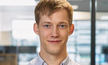 A young-middle aged white man with brown hair, wearing a shirt.