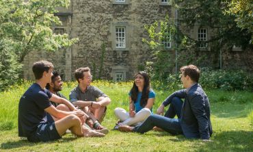 Group of students sat on the grass at St Edmund Hall College. By John Cairns. 
