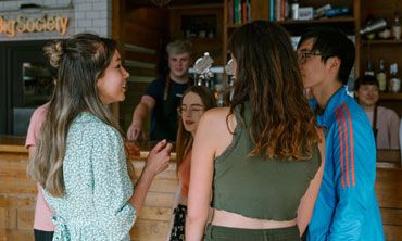 A group of students chatting in a bar