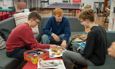 Three students playing a board game