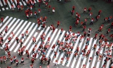 Image depicts a aerial view of many people using a crossing all with red circles around their heads