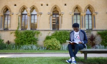 Student sat reading in front of the Museum of Natural history, Oxford. Ian Wallman