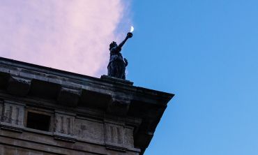 A statue on the corner of the Clarendon Building at dusk