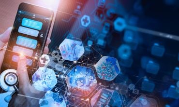 A doctor using a chatbot on a smart phone. The background has icons representing digital medicine, pills and tablets, a doctor with a stethoscope, the emergency service network, and telemedicine.