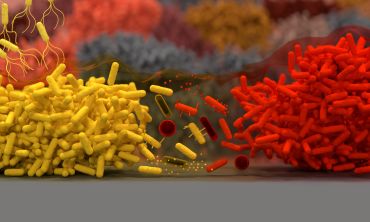 Artistic image showing two colonies of bacterial cells attacking each other. Some bacteria have released chemicals into the surrounding environment. Other bacterial cells are attacking competitors at close-range using spikes attached to their membrane.