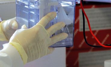 Close up of a student in a lab holding a box