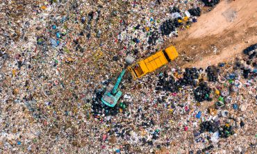Aerial view of garbage trucks unloading garbage in a landfill.