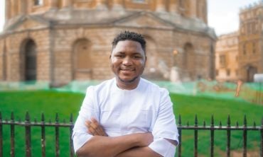 Wantoe T. Wantoe stands with arms folded in front of the Radcliffe Camera