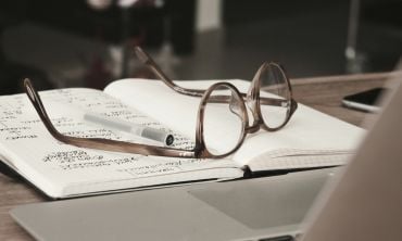 A pair of glasses resting on a notebook.