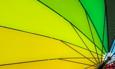 umbrella seen from below showing spokes and panels ranging from an orange through the spectrum to green