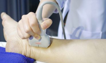 Nurse doing an ultrasound on a patient's leg