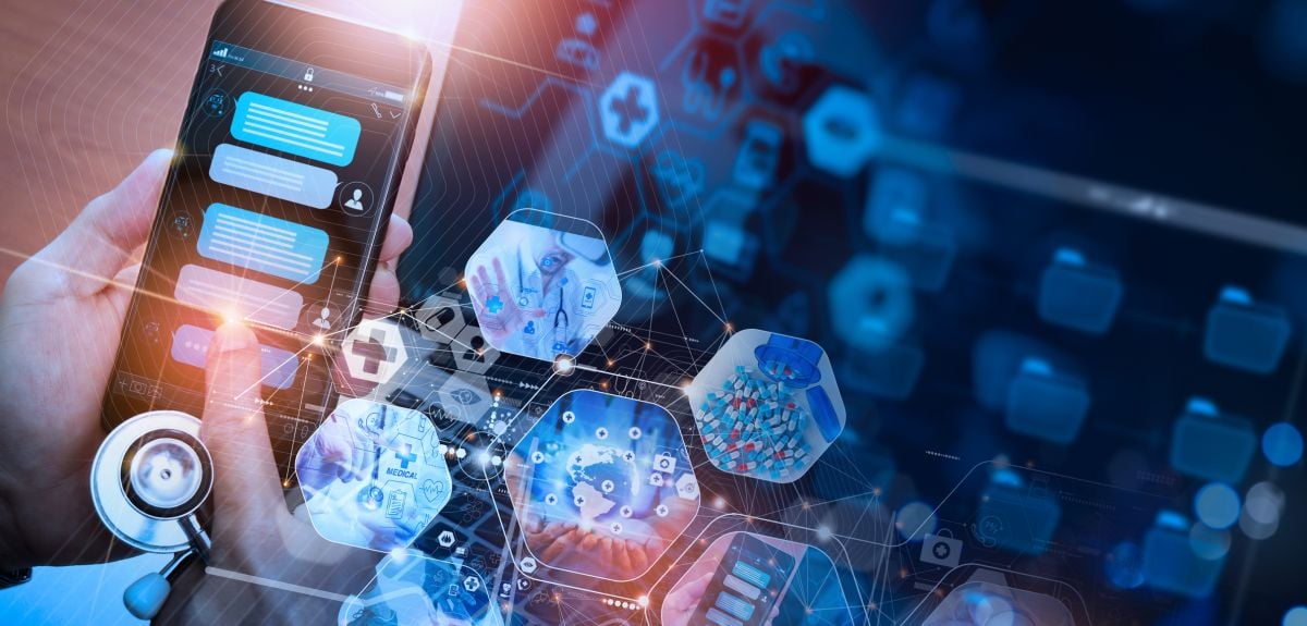 A doctor using a chatbot on a smart phone. The background has icons representing digital medicine, pills and tablets, a doctor with a stethoscope, the emergency service network, and telemedicine.