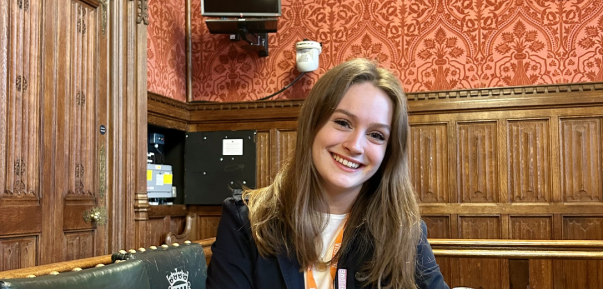 Chloe Pomfret sits at a desk in a room in the House of Commons