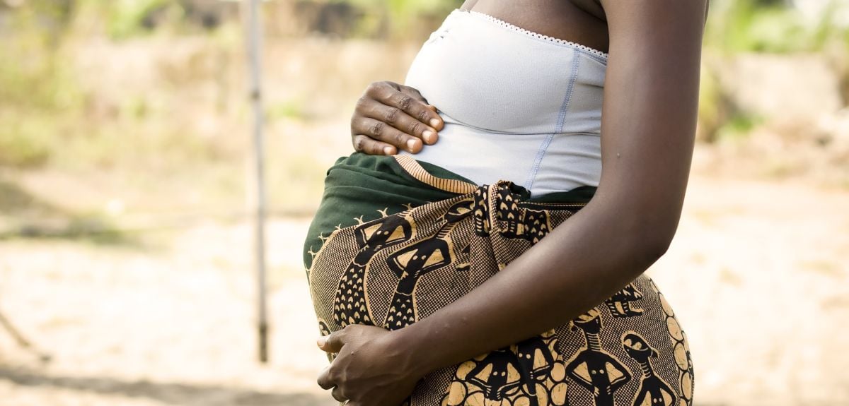A pregnant African woman holding her stomach. Credit: himarkley, Getty Images