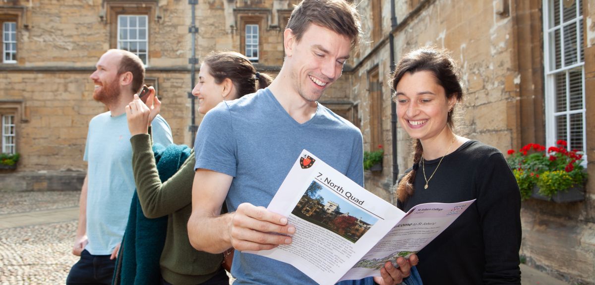 Image of visitors to Oxford Open Doors at St John's College with a guide book ready to explore