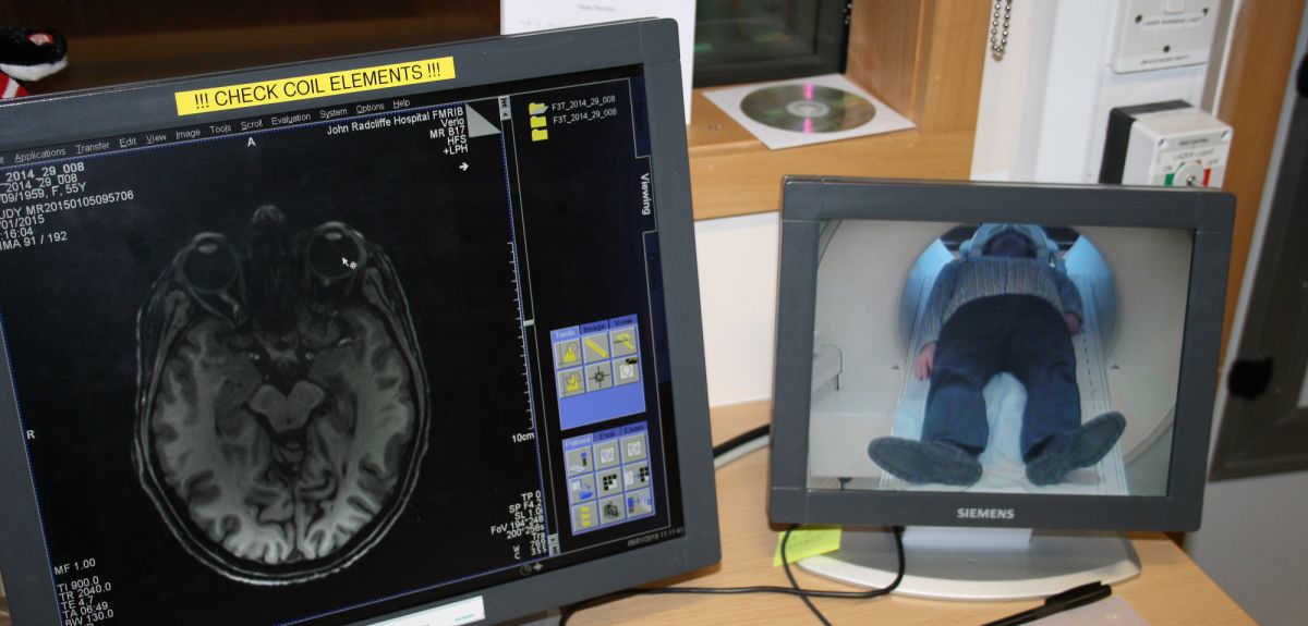 Study volunteer with one hand in brain scanner