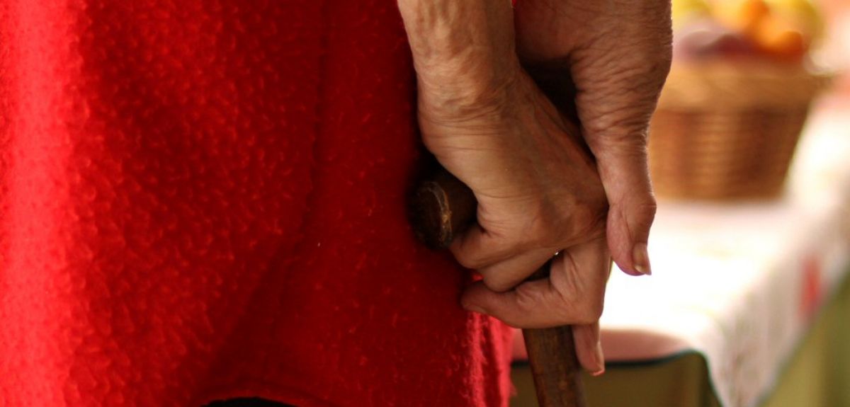 Elderly person holding hands.