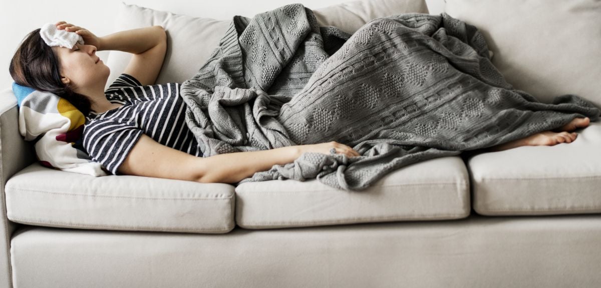 Woman laying on the couch sick with flu