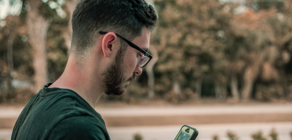 Man in glasses looking at his smartphone. Photo by Jacob Townsend on Unsplash