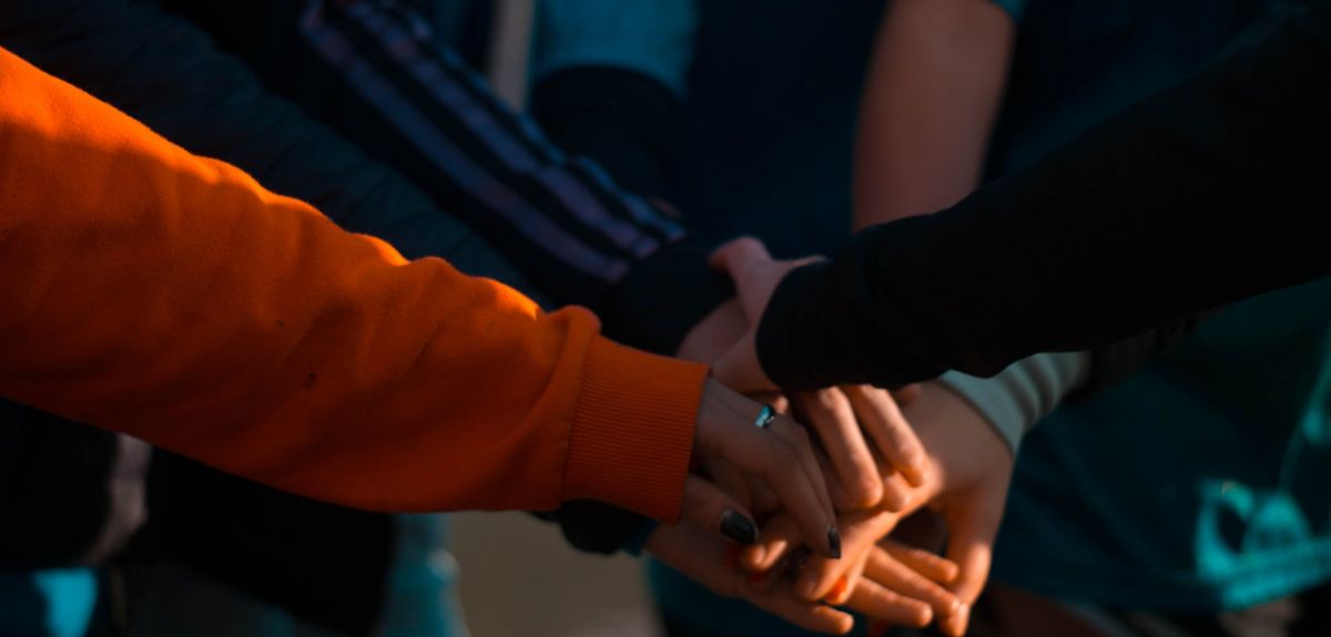 Group of people putting their hands on top of each other. Credits: Mica Asato via Pexels